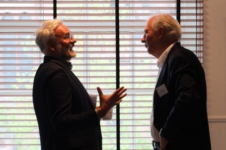 Twee mannen in gesprek op evenement, reportagefotografie