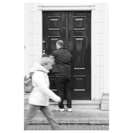 Zwart-wit foto kind bij deur, straatfotografie